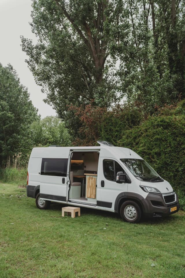 Peugeot Boxer L3H2 buscamper zijkant, staand op gras